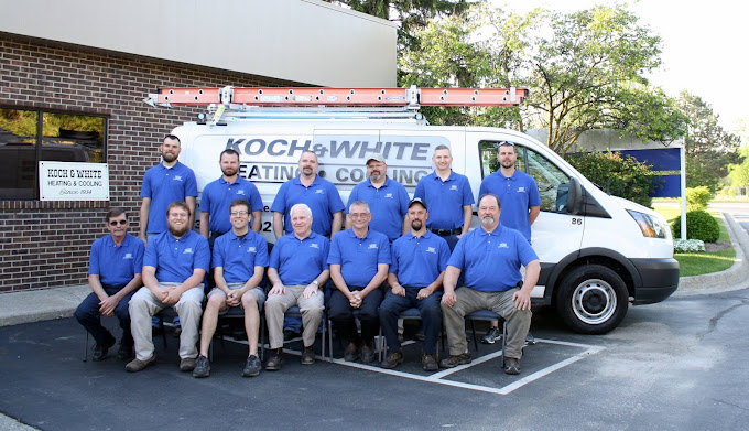 Koch & White employees smiling for a photo in front of a fleet vehicle.